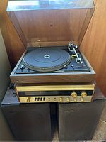 Front view showing turntable on receiver atop two speakers