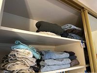 Folded stacks of men's jeans and pants including light blue vintage Levi's denim and khaki colored pants.