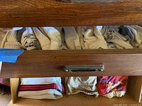 Drawer with athletic socks visible, several pairs in assorted styles and brands