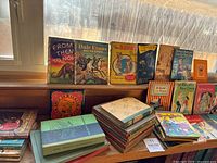Wide shot of vintage children's books displayed on a shelf, featuring a variety of titles including 'From Then To Now,' 'Dale Evans and the Coyote,' 'The Bunny Book,' and others.
