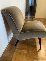 Side view showing shape and profile of chair, curved back and seat with tapered wooden legs.