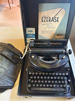 Full view of the vintage Underwood Noiseless 77 typewriter inside its open hard case with accessories including the soft cover, Instant Type Cleaner box, and Miller Falls Typerease Papers booklet.