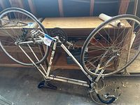 Full side view of vintage white Peugeot Record Du Monde 10 speed road bike without front wheel attached, showing steel frame, rear wheel, crankset, chain, and drop handlebars.