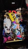 Full bin shot showing variety of toys including dolls, Minecraft figures, and toy bus