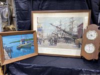 Lot contents showing three items: maritime linen print in frame, vintage wooden weather station with dials, and large framed historical shipyard print.