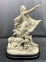 Front view showing veiled female figure with flowing fabric and floral details with reclining figures below