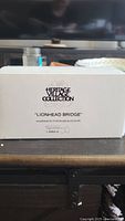 Photo of the box for the 'Lionhead Bridge' porcelain accessory from Heritage Village Collection by Department 56.