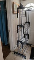Photo of the drying rack showing its full height, multiple drying tiers, black plastic connectors, metal rods, and wing hooks.