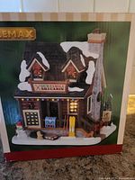 Box image showing Lemax brand and Our Family Ski Cabin label.