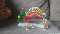 Overall view of the Grinch archway and characters on grey fabric surface showing the full set and arrangement.