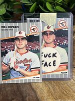 Photo showing two Billy Ripken baseball cards: the left one is a standard 1989 Fleer card; the right one is the infamous 1989 Fleer 616 Black Box error card with explicit wording visible.