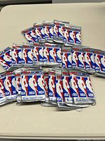 Five unopened sealed packs of 1990 NBA Hoops NBA basketball trading cards with branding visible.