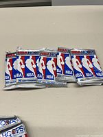 Five unopened 1990 NBA Hoops basketball card packs arranged in a row.