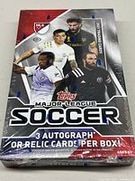 Front view of sealed 2021 Topps MLS Soccer trading card box showing player images and 3 autographs or relic cards per box promise.