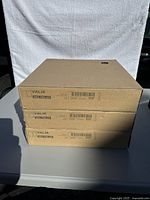 Stack of three IKEA VALJE wall cube shelves still in their original cardboard boxes, showing product labels.