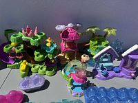 Photo showing five colorful Hatchimals-themed playsets with nature and house elements and various decorative parts.