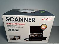 Front view of box showing brand Kedok with product description as photo and film scanner for photos, slides, negatives, and name cards.