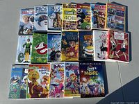 Photo showing 20 kids DVD movie titles arranged on a flat surface, including new and used copies of classic and animated kids films.