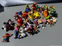 Full lot overview showing many colorful vintage cartoon character figures posed on a surface.