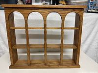 Front view of wooden wall-mounted display shelf with 12 open compartments, showing overall structure and design.