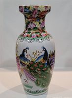 Full front view of the vase showing the entire peacock design and floral motifs.