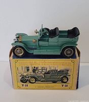 Front angle of the green antique Matchbox car on its original yellow box.