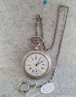 Full view of pocket watch, chain and tag