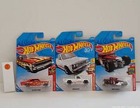 Photo showing three new Hot Wheels collectible cars in original packaging: Chevrolet El Camino, Mazda REPU, Bone Shaker.