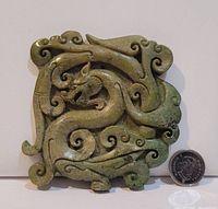 Full front view of the square jade pendant with a coin alongside for scale