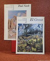 Two art books from The Masters Publications, featuring cover art by Paul Nash and El Greco, placed upright against a red backdrop.