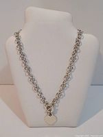 Full view of the sterling silver chain necklace with heart pendant displayed on a white bust.