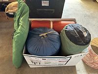 Top view of box containing two sleeping bags and rolled sleeping pads