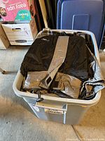 Photo of a black and gray Strata jacket in a large gray bin.