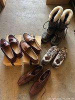 All five pairs of men's shoes displayed together showing dress shoes, snow boots, and athletic shoes.