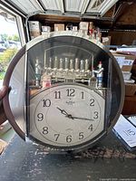 Full view of the 15.5-inch Small World Rhythm musical clock with visible clock face and upper musical decorative elements