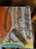 Overview of all six jewelry pieces displayed on a towel showing assortment of necklaces and a bracelet.