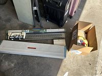 Overview photo of the knitting machine parts laid on ground with cover and accessory box visible