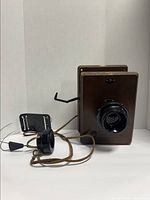 Front-side view of the 1954 CN Railway wooden wall telephone with original black handset connected by cord, showing the crank on the side.