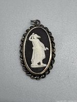 Front view of the Wedgwood pendant showing classical figure in white relief on black background within twisted silver bezel.