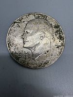 Obverse of the 1976 Eisenhower Silver Dollar showing worn Eisenhower profile and inscriptions