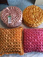 Top view of all four pillows arranged in two rows on floor, showing colors and textures.