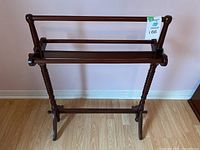 Wooden blanket rack front view showing structure and horizontal rods for holding blankets.