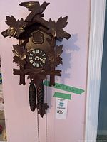 Full front view of carved wooden cuckoo clock mounted on wall