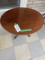 Top view of the oval wooden table showing surface and seller tags including measurements