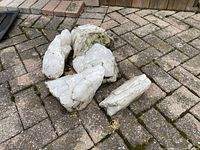 Five white quartz rocks placed on a brick patio surface, showing size and texture.