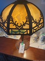 Full view of lamp showing metal framework and amber slag glass shade