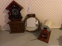 Overview photo of all four vintage decorative items together on floor against wallpapered wall.