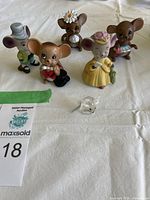 Group photo of five vintage ceramic mice figurines with various outfits and one small clear Swarovski crystal mouse on white fabric surface.