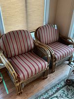 Front view of both chairs showing striped cushions and rattan frame