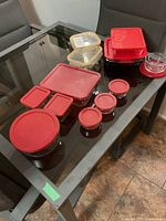 Overview of all glass storage containers including red-lidded Ancor Hocking dishes, clip-seal containers, and small round jars.